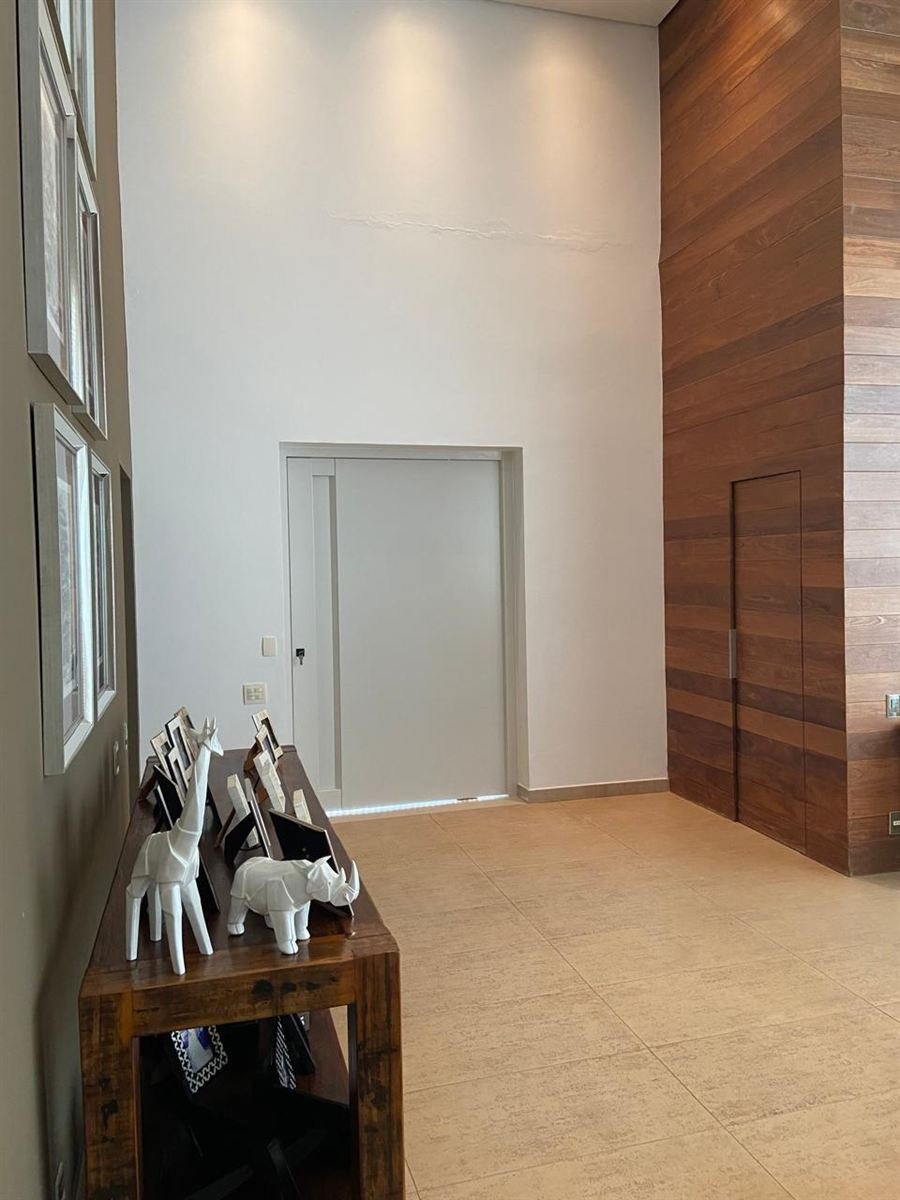 Porta em ACM branco offwhite embutida em parede amadeirada