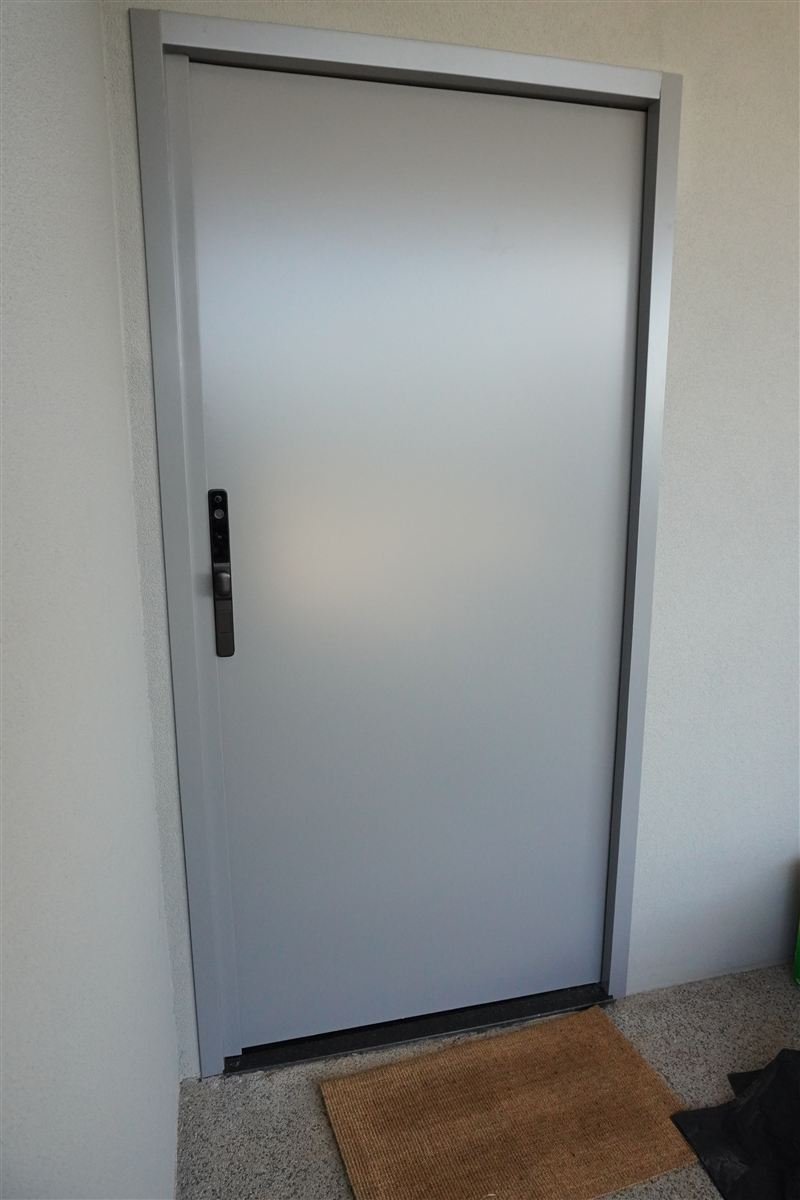 Porta de correr em ACM cinza com fechadura digital