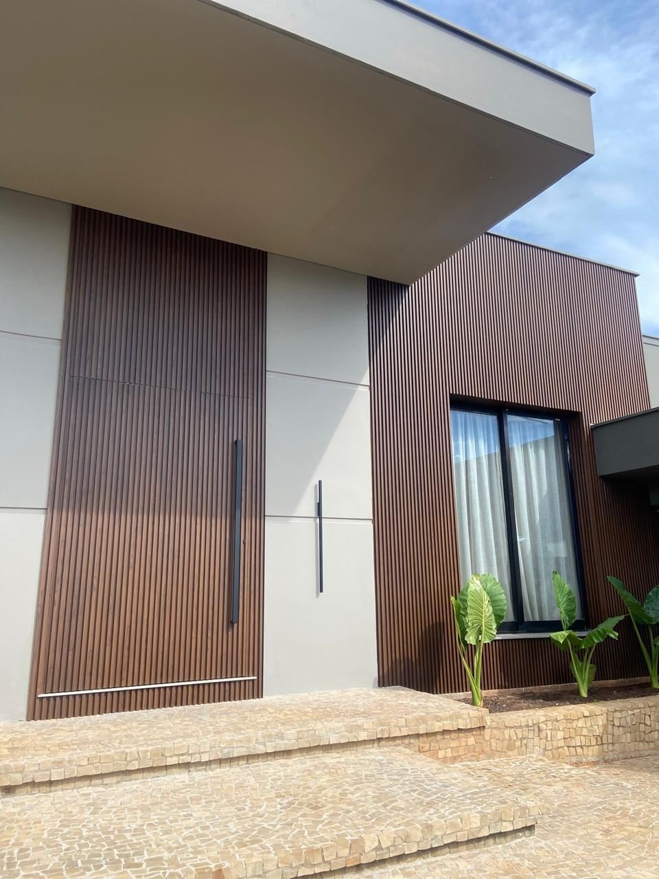 Fachada ripada amadeirada em ACM com porta pivotante - projeto Aluminium Concept